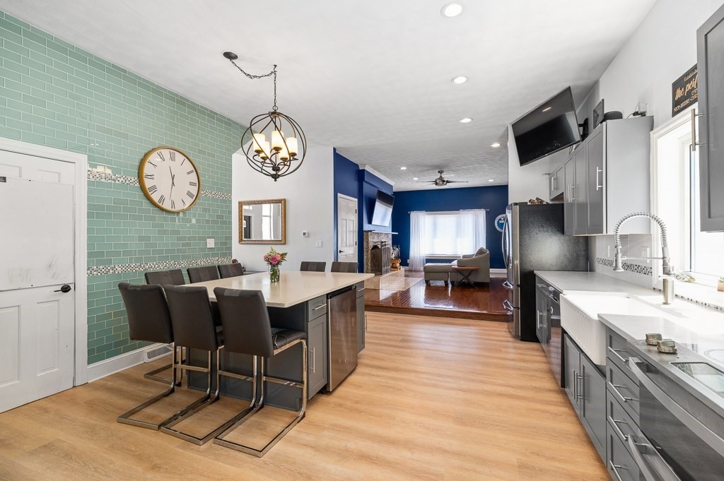 20 Landers Road Stoneham, MA 02180 - Photo 8 of 36 a large kitchen with a table and a clock on the wall