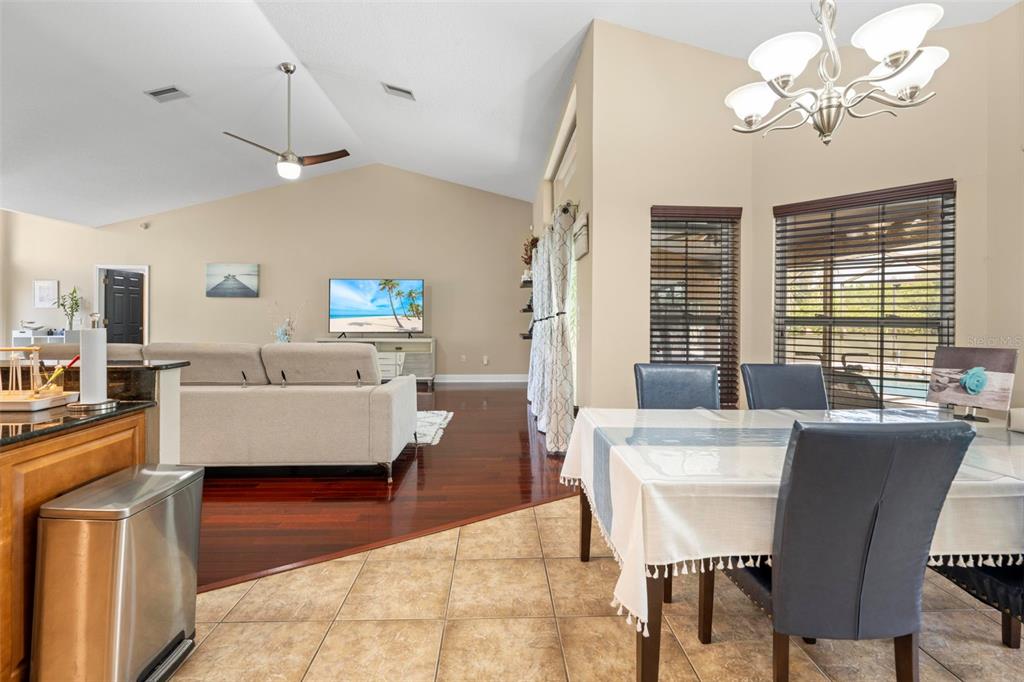 14207 Cornewall Lane Spring Hill, FL 34609 - Photo 21 of 63 a view of a dining room with furniture a chandelier and wooden floor