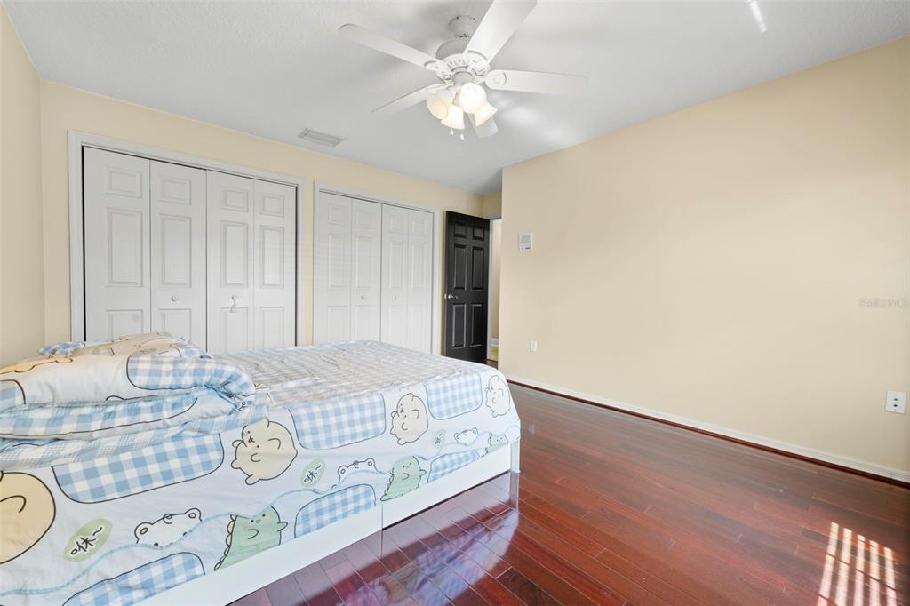 14207 Cornewall Lane Spring Hill, FL 34609 - Photo 42 of 63 a bedroom with a bed and a chandelier