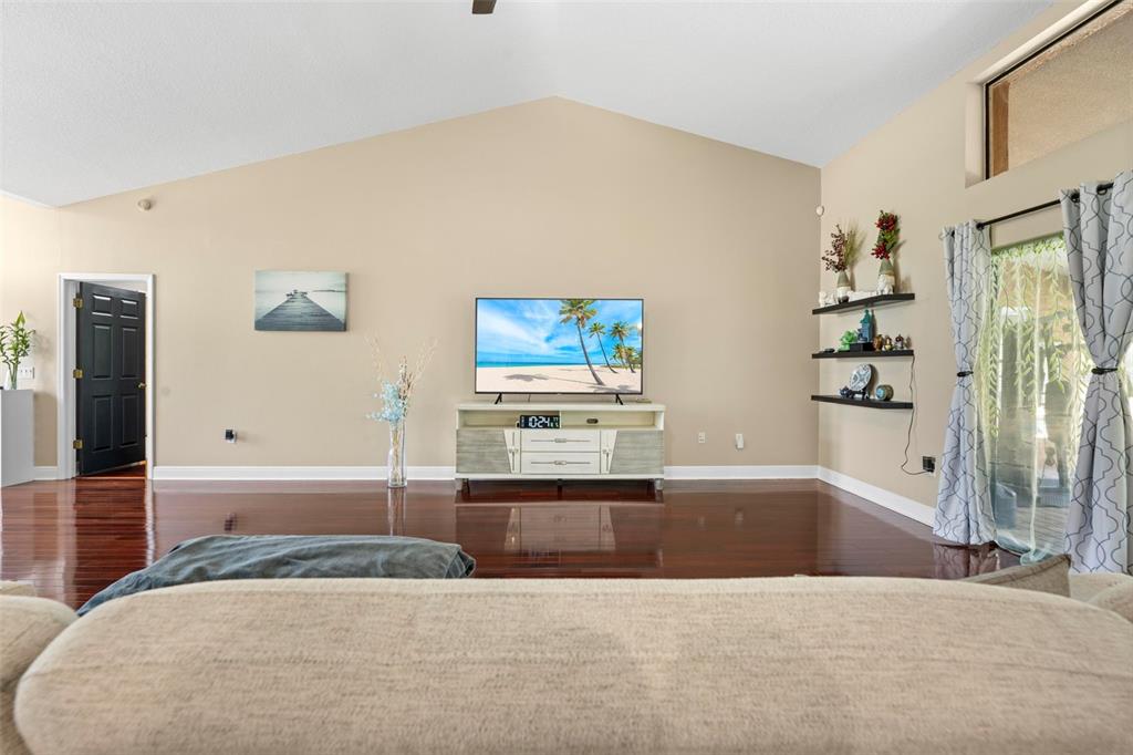 14207 Cornewall Lane Spring Hill, FL 34609 - Photo 10 of 63 a bedroom with a large bed and a chandelier