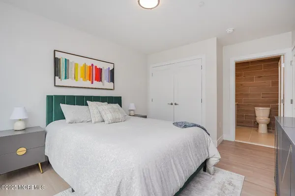 a bedroom with a bed and a painting on the wall