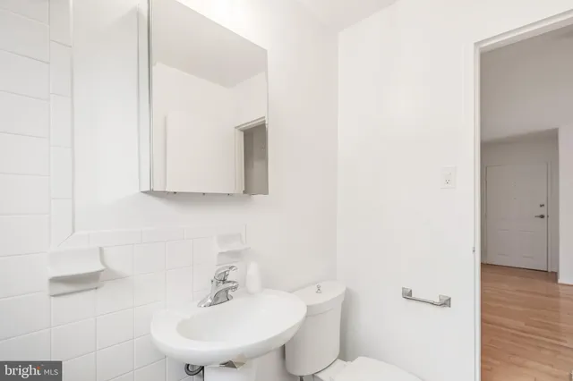a bathroom with a sink toilet and a mirror