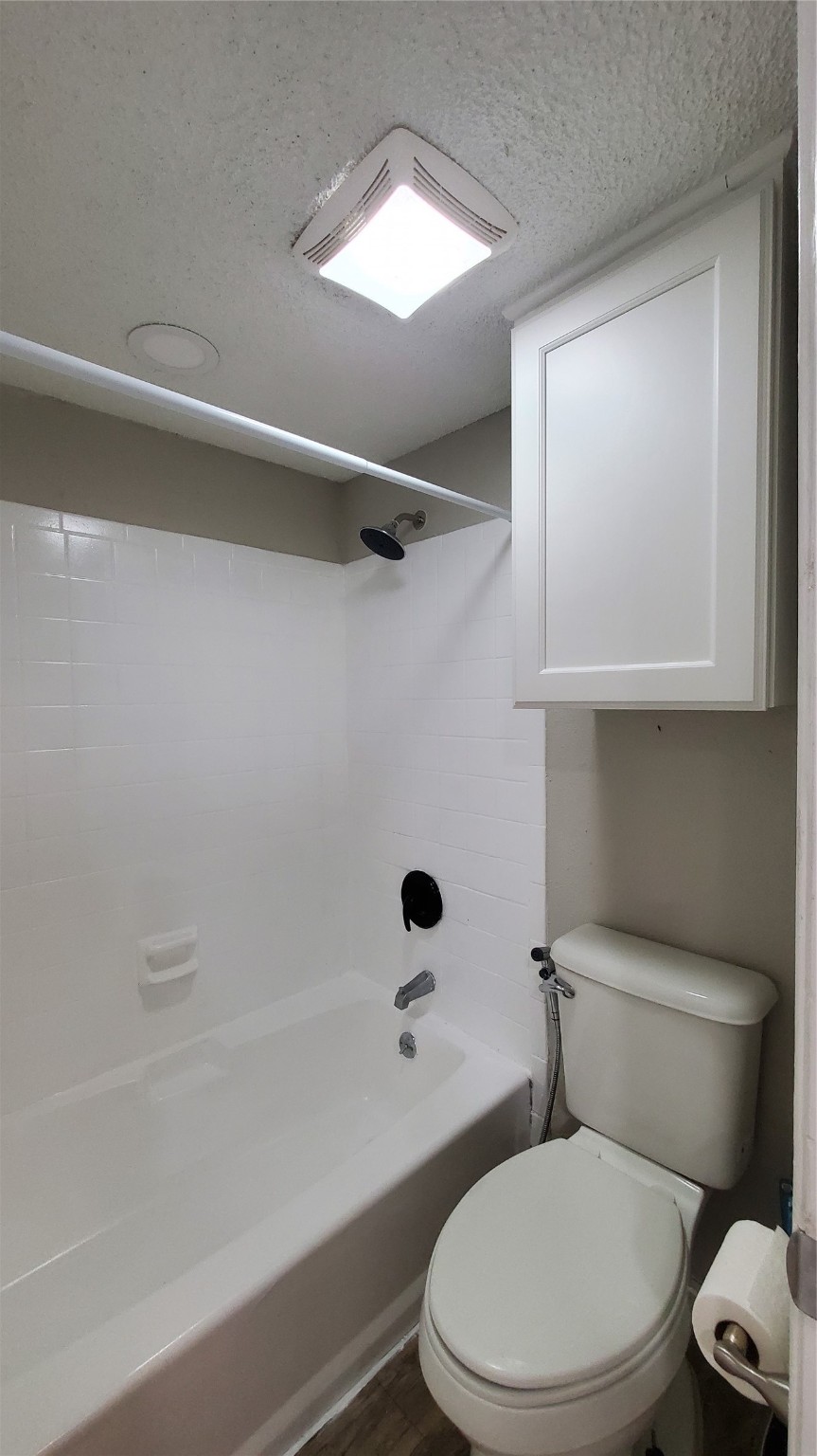 3768 Tanglewilde Street, Unit J5 Houston, TX 77063 - Photo 13 of 24 a white toilet sitting next to a bath tub