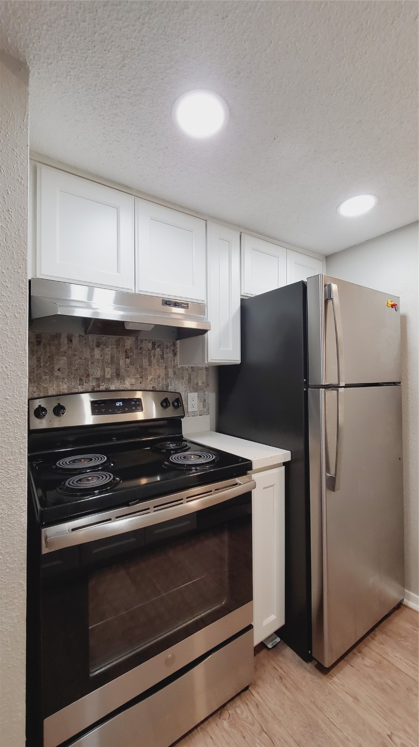 3768 Tanglewilde Street, Unit J5 Houston, TX 77063 - Photo 5 of 24 a kitchen with a stove and a refrigerator