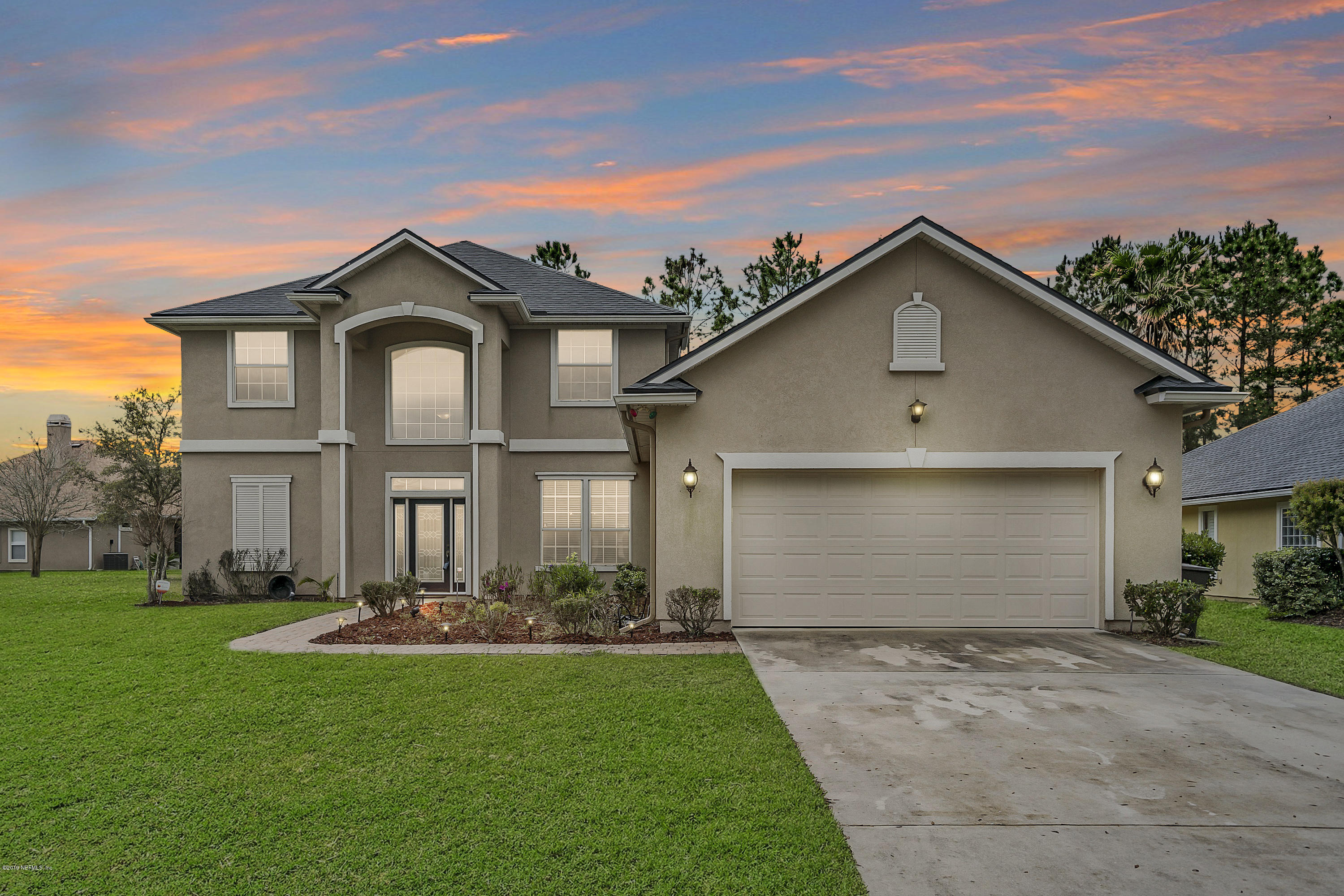 a front view of a house with a yard and garage