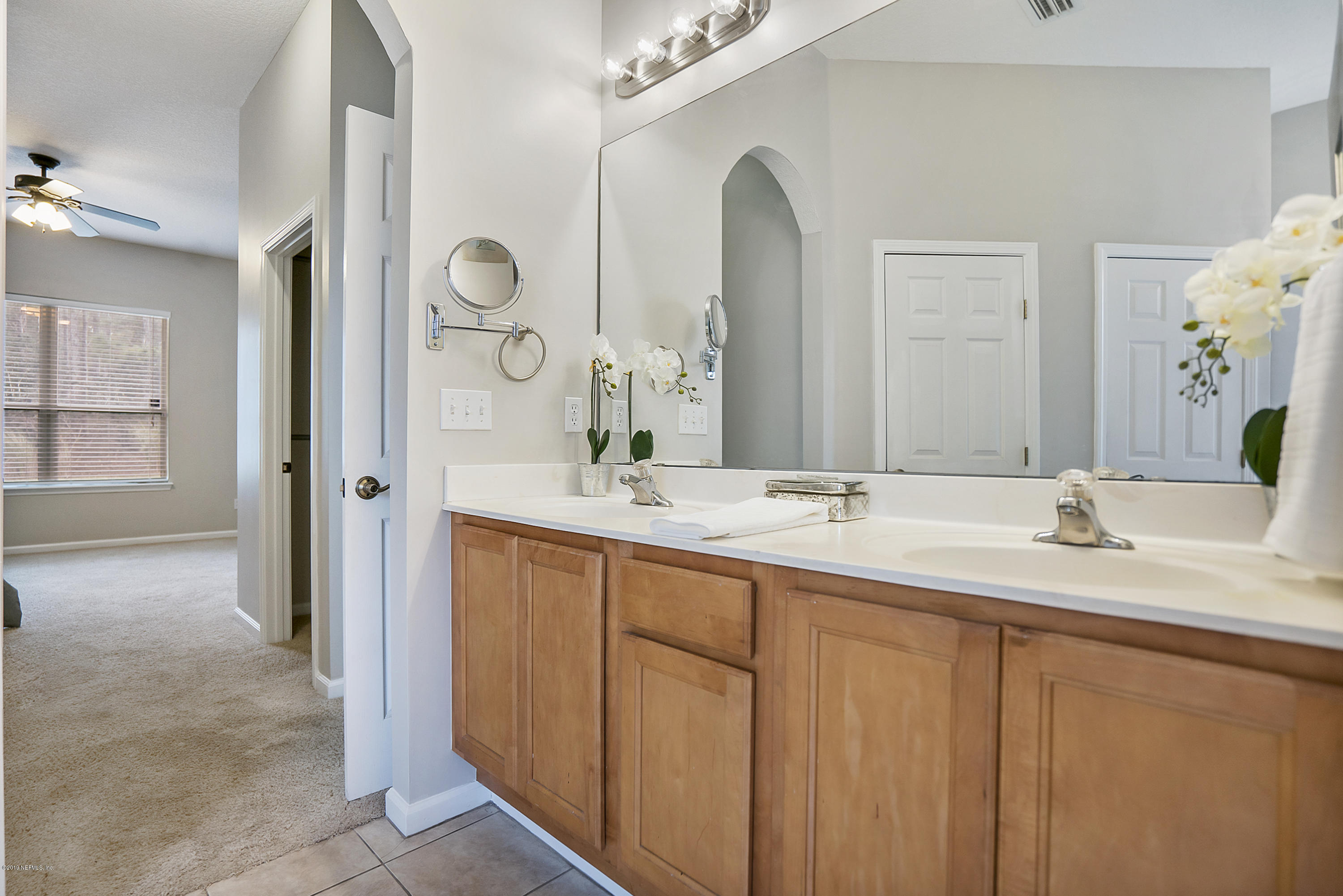 1409 Riva Del Garda Way St. Augustine, FL 32092 - Photo 15 of 41 a bathroom with double vanity sinks and a mirror