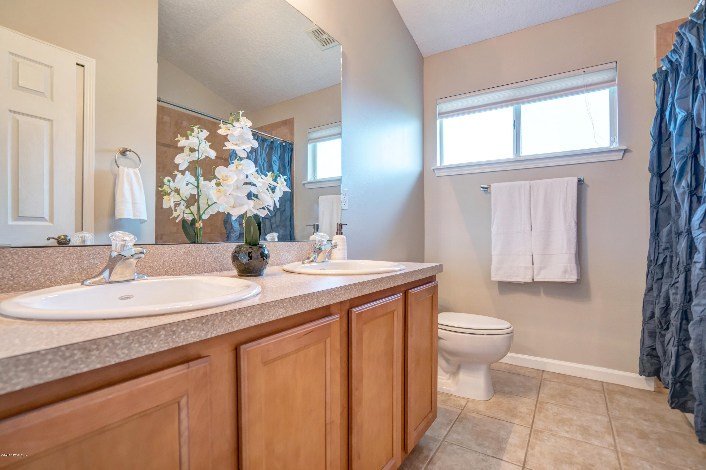 1409 Riva Del Garda Way St. Augustine, FL 32092 - Photo 20 of 41 a bathroom with a granite countertop sink toilet and mirror