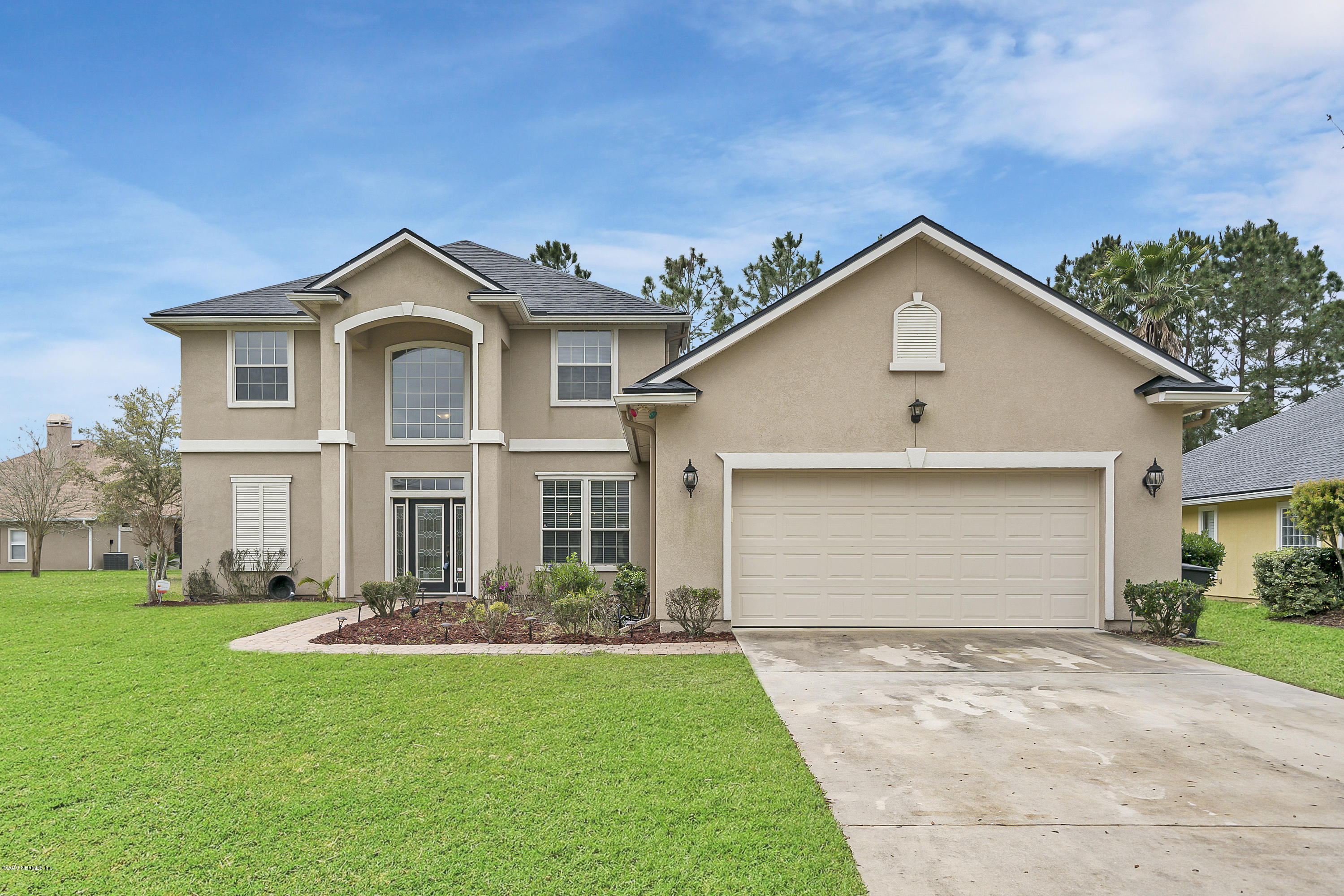 1409 Riva Del Garda Way St. Augustine, FL 32092 - Photo 2 of 41 a front view of a house with a yard and garage