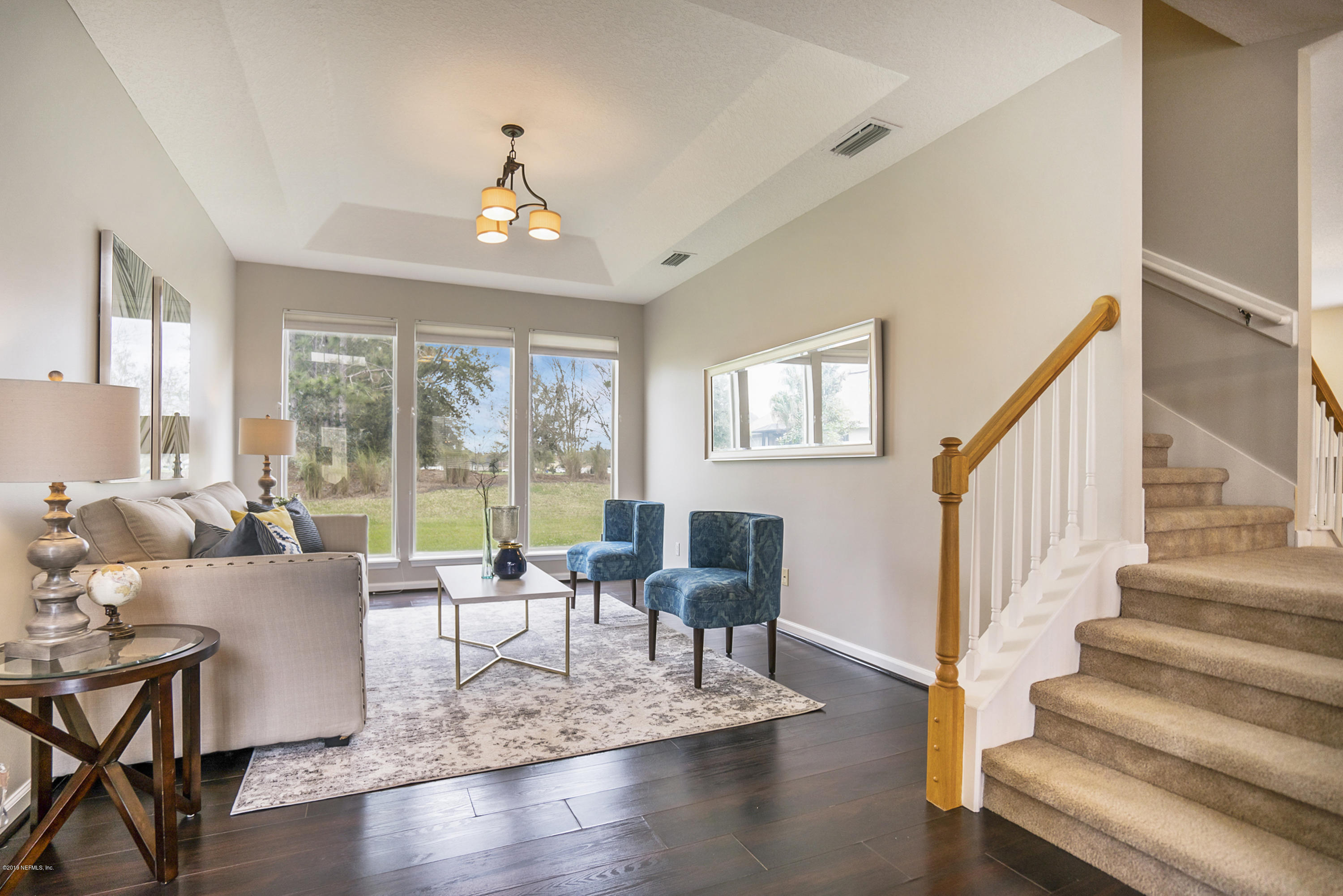 1409 Riva Del Garda Way St. Augustine, FL 32092 - Photo 4 of 41 a living room with furniture large windows and wooden floor