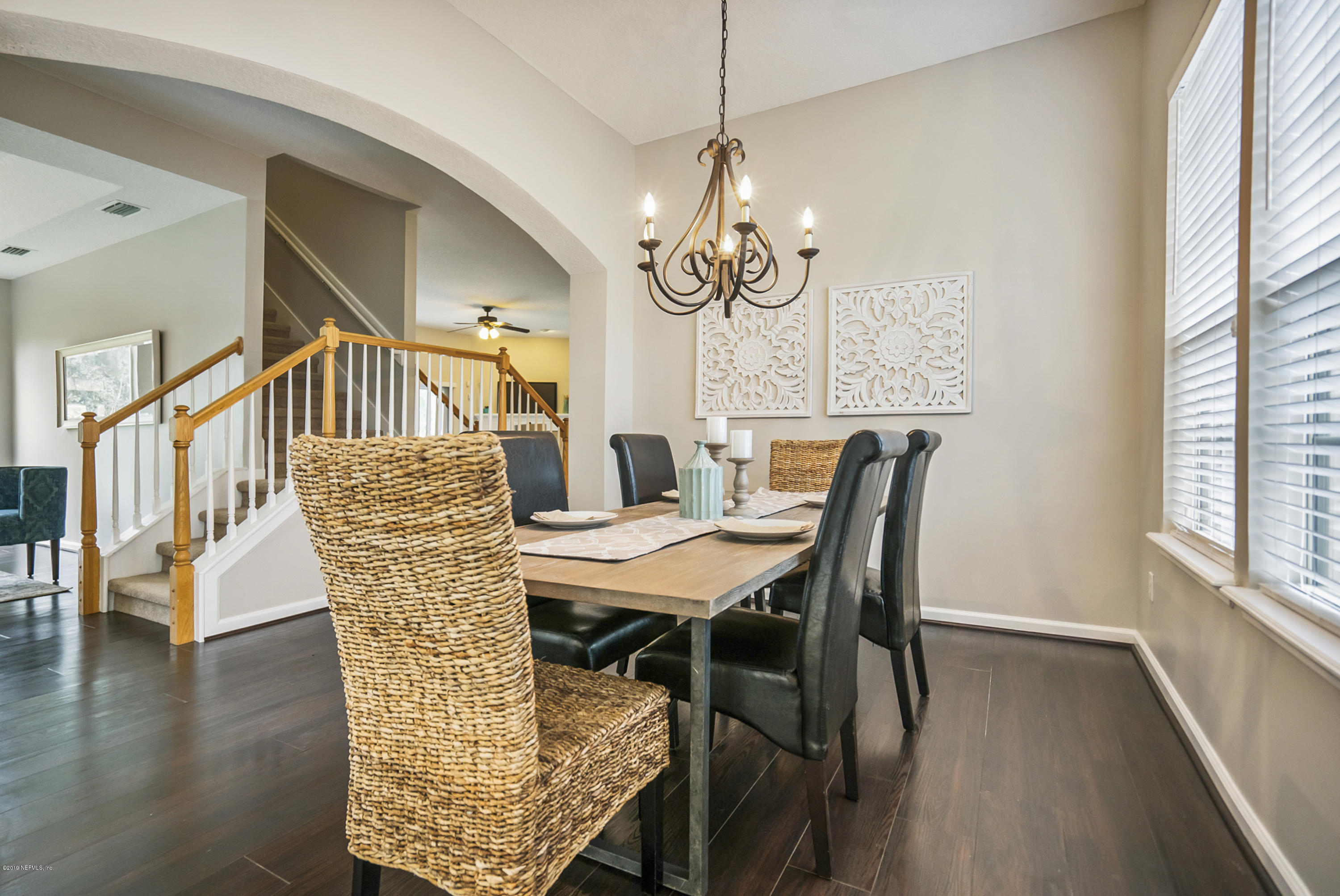 1409 Riva Del Garda Way St. Augustine, FL 32092 - Photo 5 of 41 a dining room with wooden floor a chandelier a wooden table and chairs