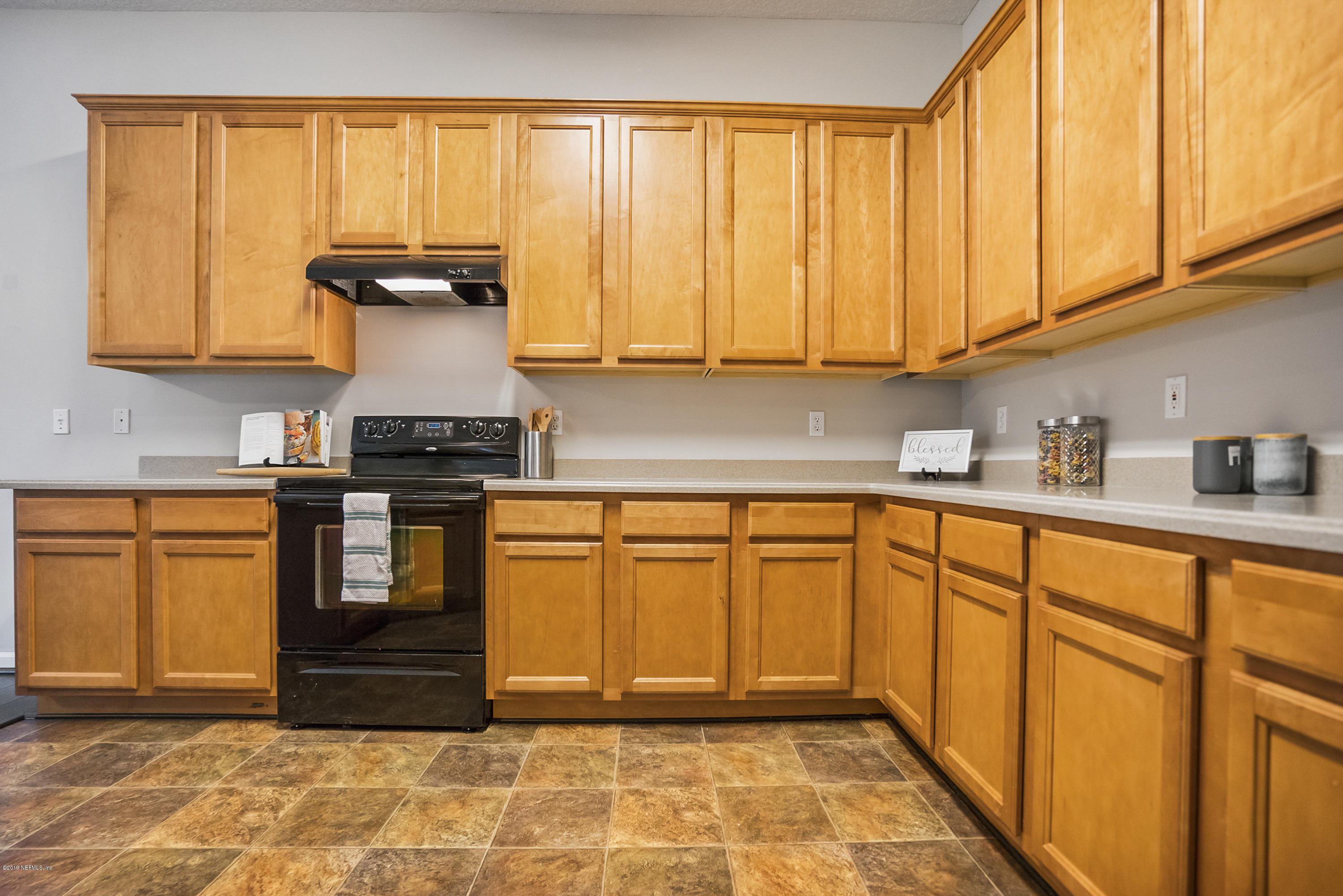 1409 Riva Del Garda Way St. Augustine, FL 32092 - Photo 7 of 41 a kitchen with stainless steel appliances granite countertop a stove a sink and white cabinets