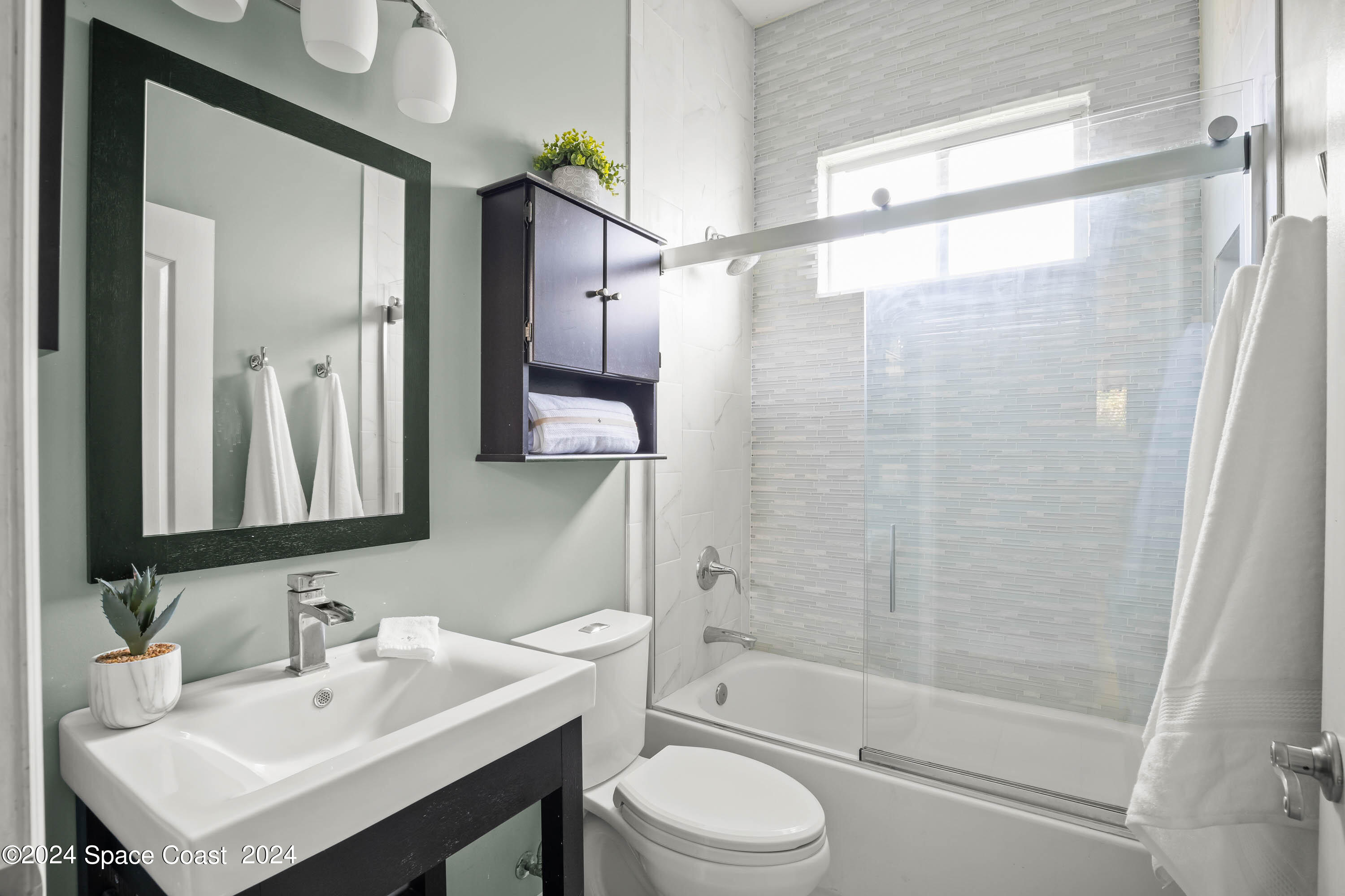 1122 Jan's Place Melbourne, FL 32940 - Photo 24 of 42 a bathroom with a sink mirror toilet and shower