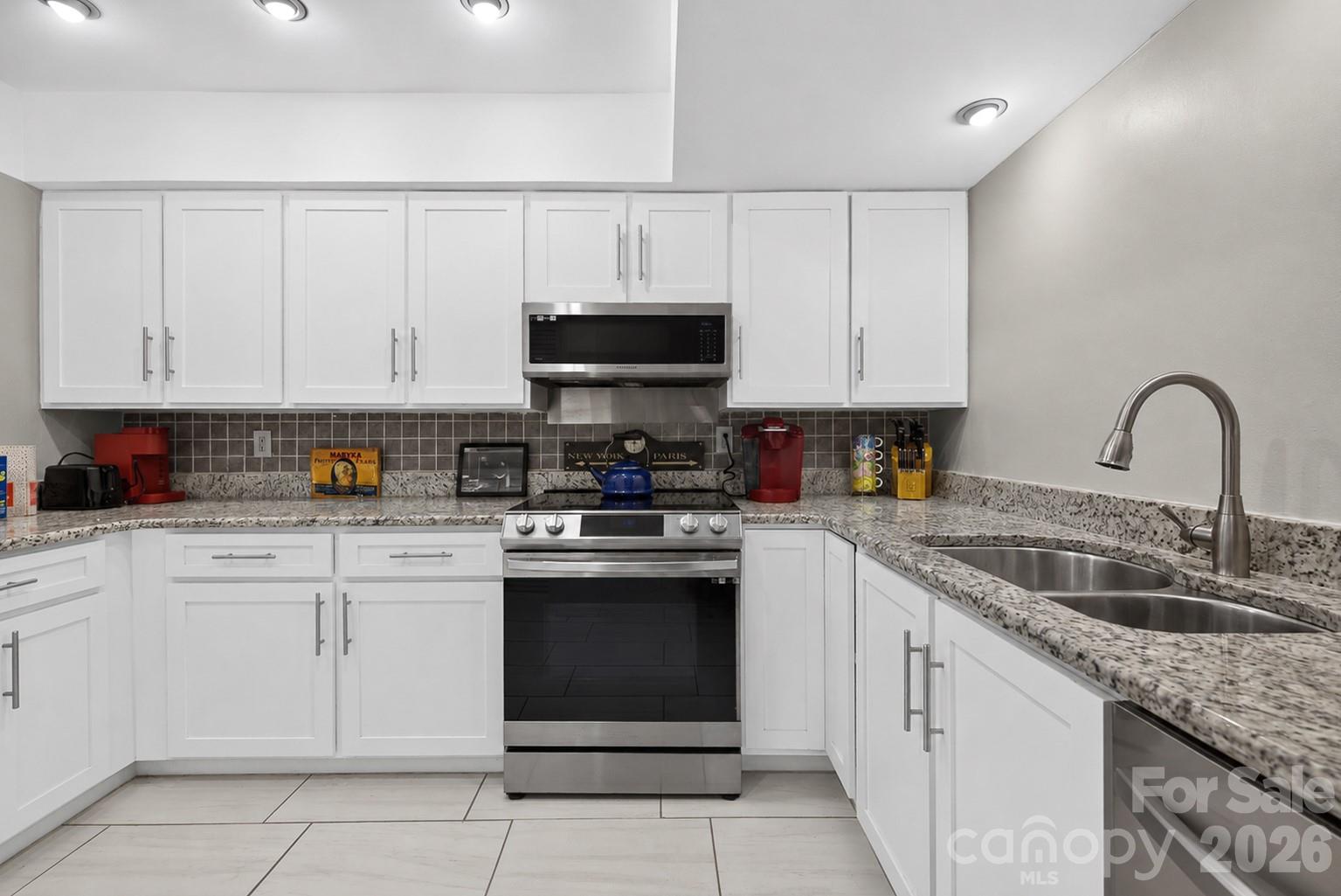 185 Riverview Terrace Clover, SC 29710 - Photo 7 of 35 a kitchen with white cabinets a sink and a stove with wooden floor