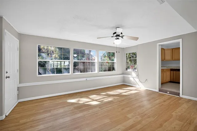 a view of an empty room with a window and wooden floor