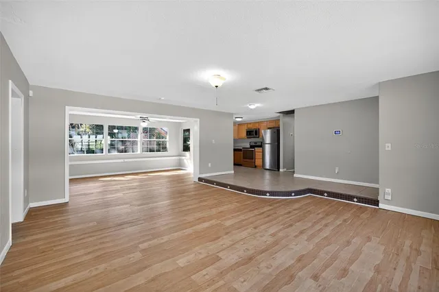 a view of empty room with wooden floor and fireplace
