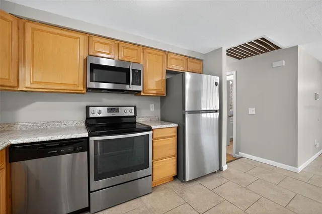 a kitchen with stainless steel appliances granite countertop a refrigerator stove and microwave