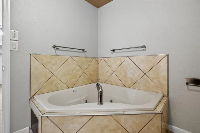 a bath tub sitting next to a white sink and a shower