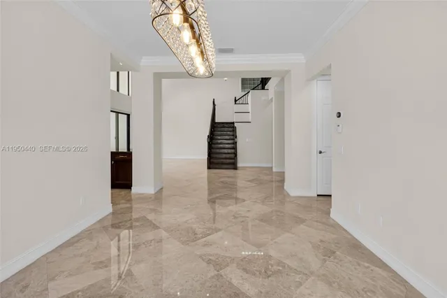 an empty room with wooden floor ceiling fan and windows