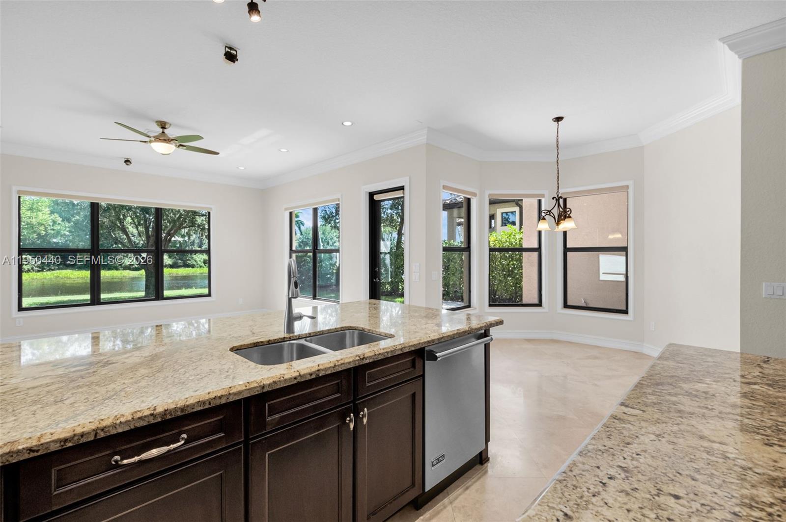 8944 Little Falls Way, Unit 8944 Delray Beach, FL 33446 - Photo 17 of 98 a large kitchen with granite countertop a sink and dishwasher with wooden floor