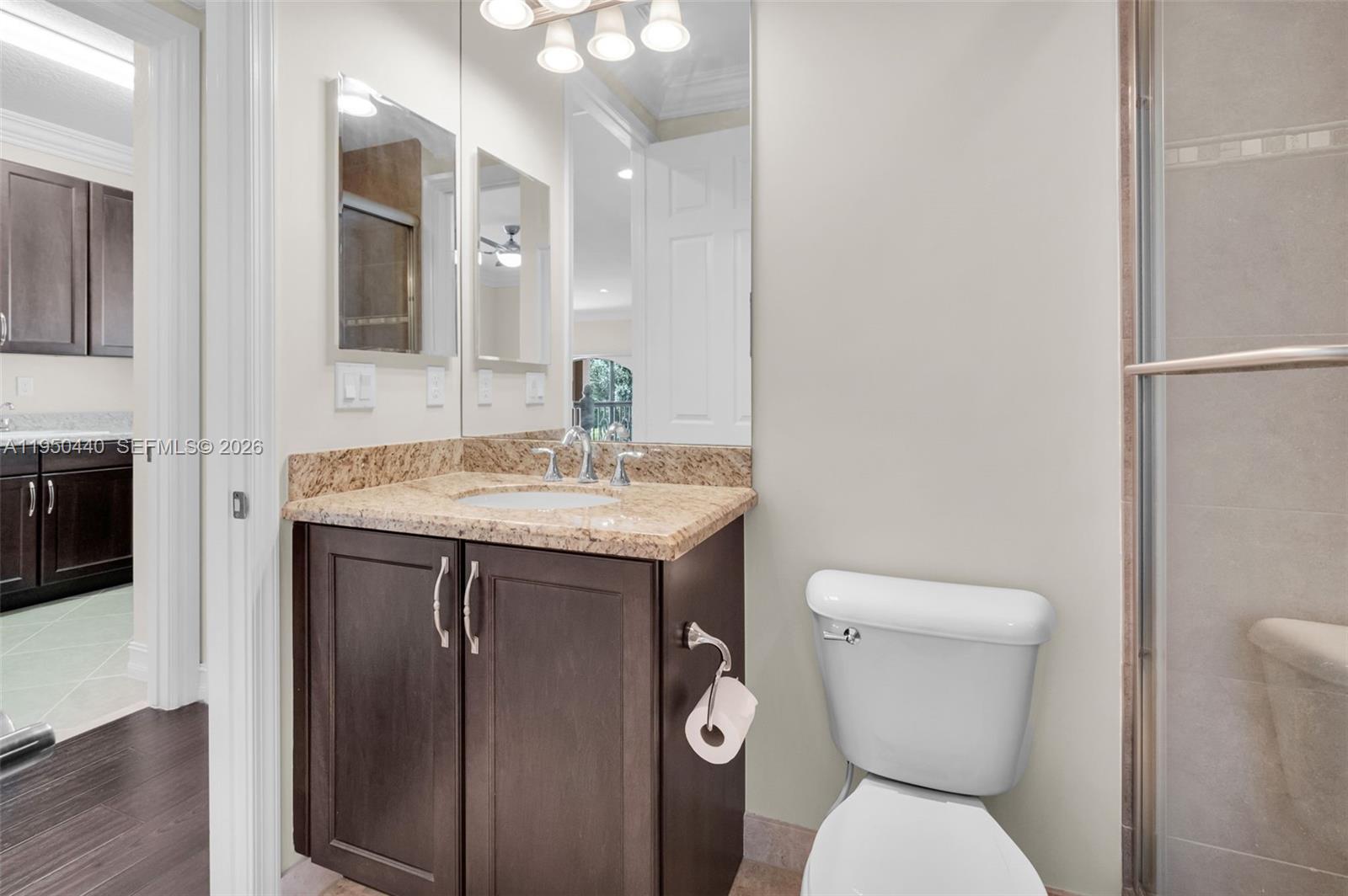 8944 Little Falls Way, Unit 8944 Delray Beach, FL 33446 - Photo 33 of 98 a bathroom with a toilet sink and mirror