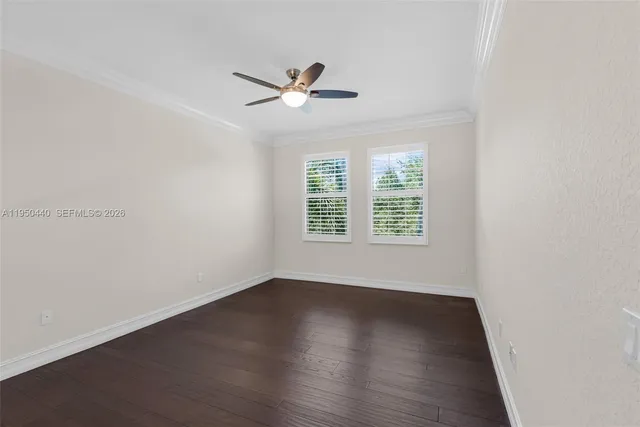 a view of a dining room with furniture a chandelier and large windows