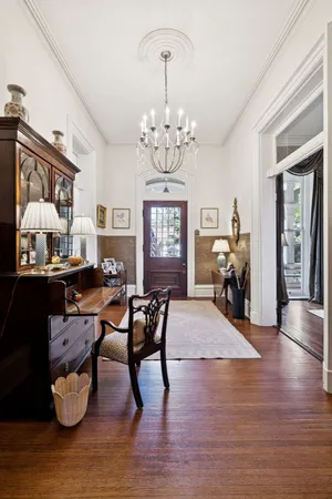 a view of a dining room with furniture a chandelier and wooden floor