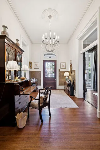a view of a dining room with furniture a chandelier and wooden floor