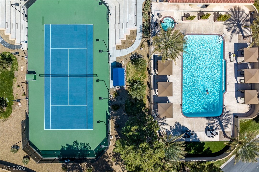 20 Innisbrook Avenue Las Vegas, NV 89113 - Photo 33 of 39 An aerial perspective reveals a vibrant tennis court alongside a inviting pool and spa, ideal for recreation.
