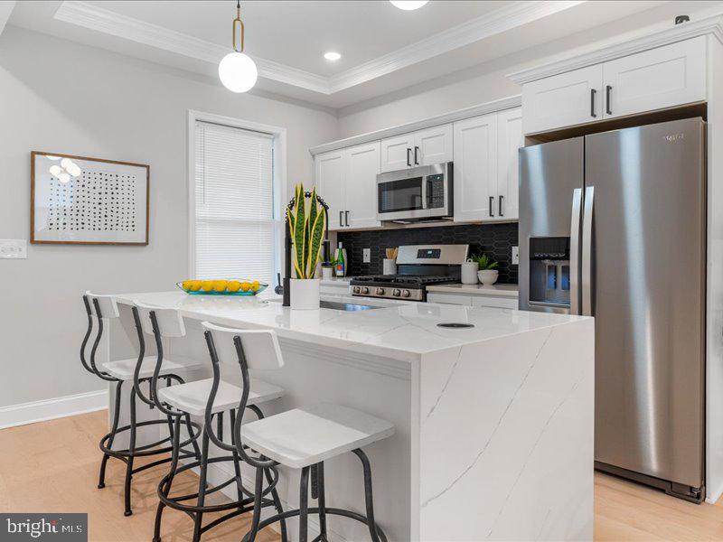 1645 Normal Avenue Baltimore, MD 21213 - Photo 13 of 53 a kitchen with stainless steel appliances a refrigerator and a stove top oven