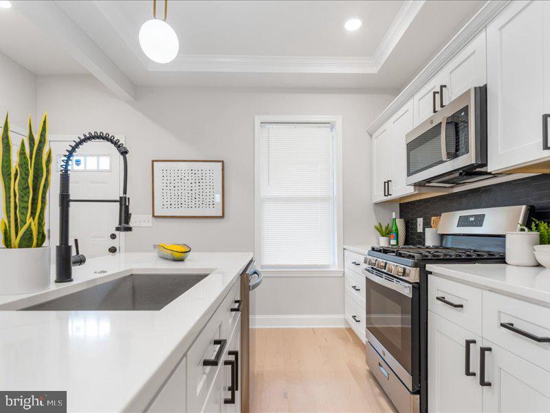 1645 Normal Avenue Baltimore, MD 21213 - Photo 17 of 53 a kitchen with stainless steel appliances granite countertop a sink and a stove