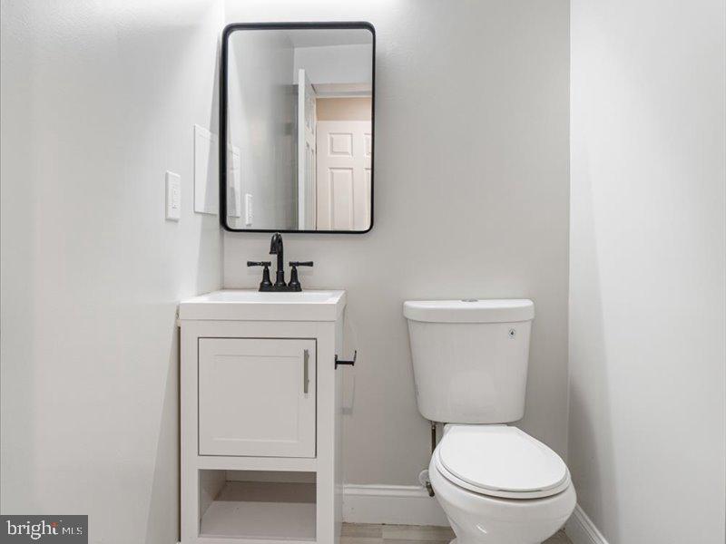 1645 Normal Avenue Baltimore, MD 21213 - Photo 23 of 53 a bathroom with a toilet sink and mirror