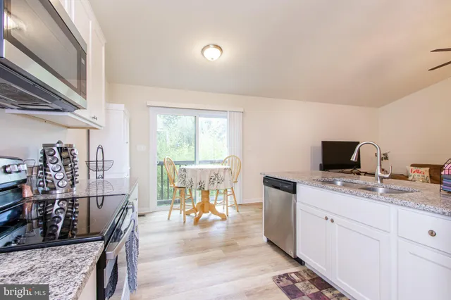 a kitchen with a sink a stove and a wooden floor