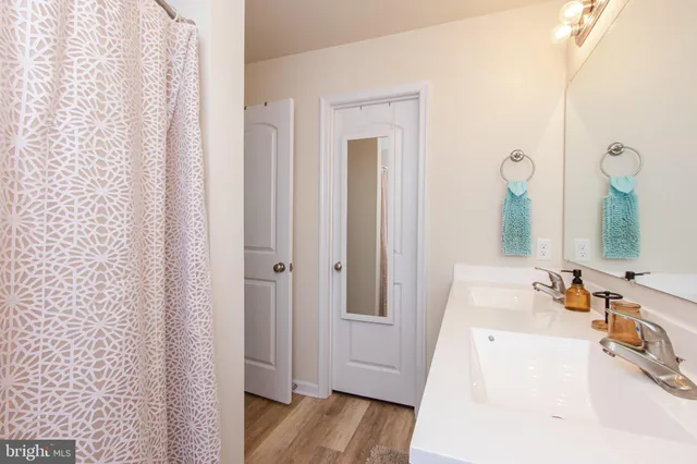 a bathroom with a tub sink and mirror