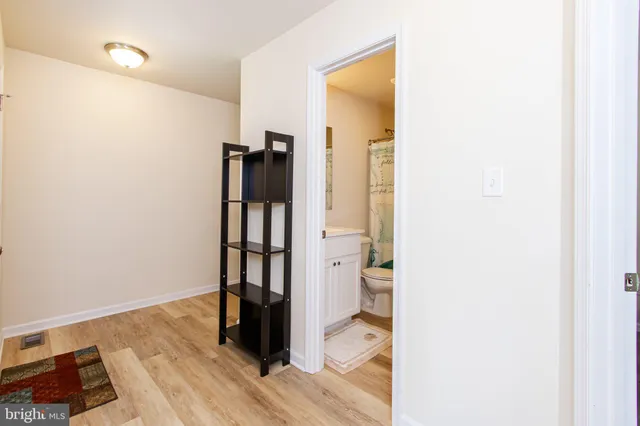 a view of a hallway with wooden floor and dining room