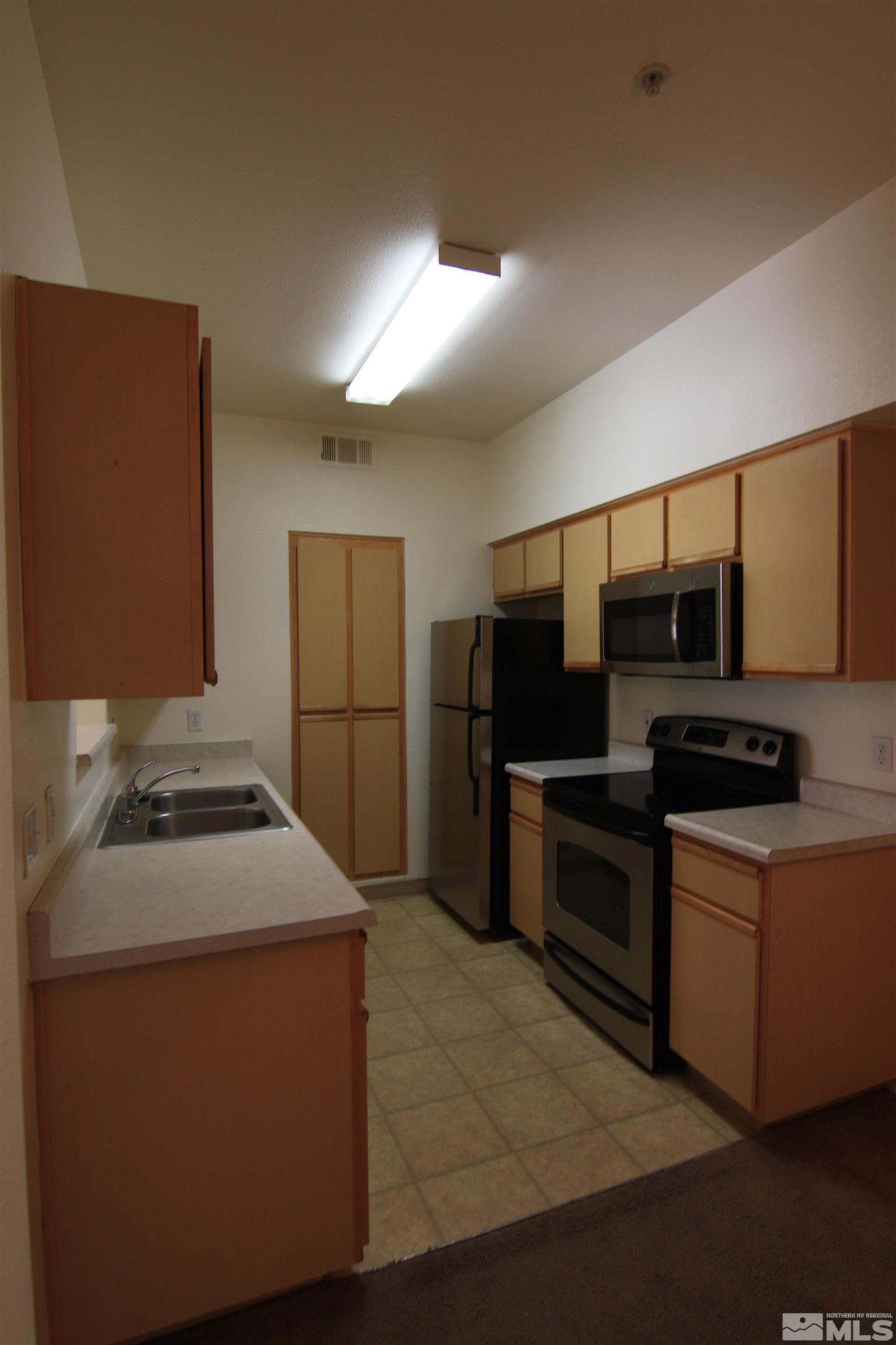 6850 Sharlands Avenue, Unit 1091 Reno, NV 89523 - Photo 3 of 11 a kitchen with stainless steel appliances granite countertop a sink and a stove
