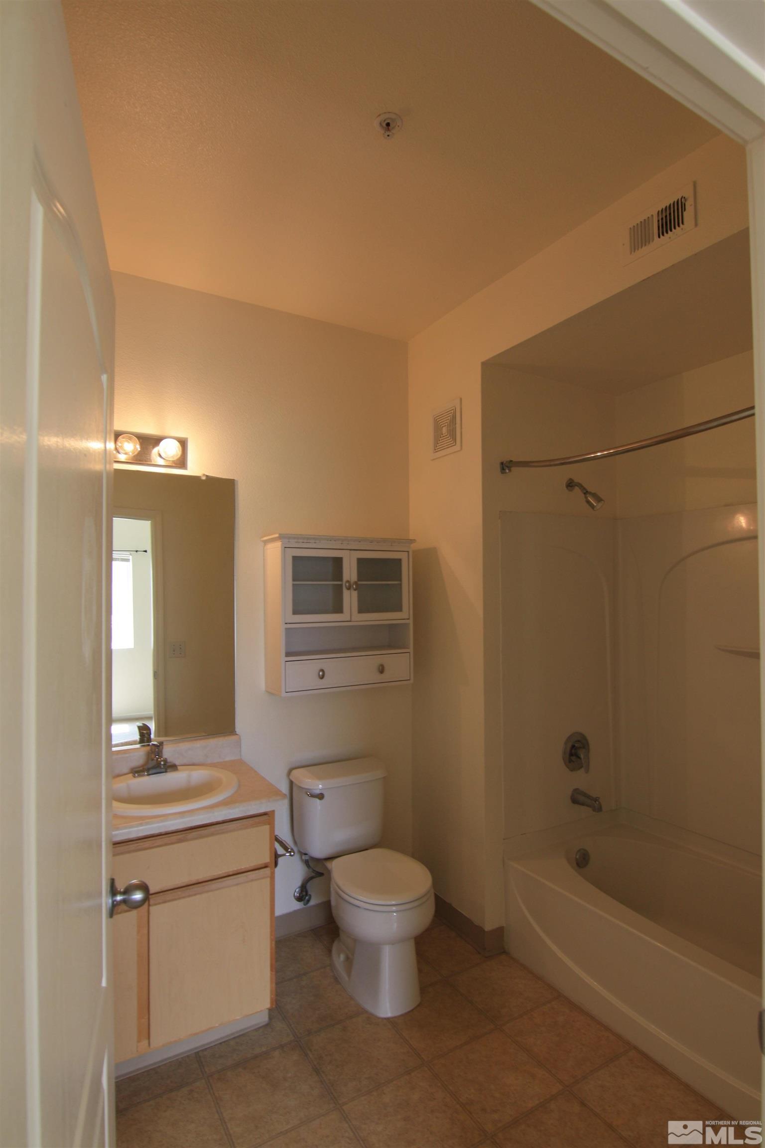 6850 Sharlands Avenue, Unit 1091 Reno, NV 89523 - Photo 8 of 11 a bathroom with a granite countertop toilet a sink and bathtub