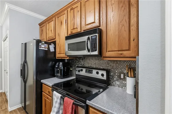 a kitchen with stainless steel appliances granite countertop a stove microwave refrigerator and sink