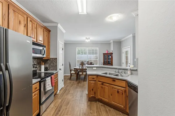 a kitchen with stainless steel appliances granite countertop a refrigerator a stove and a sink with cabinets