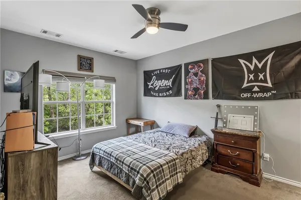 a bedroom with a bed dresser and window