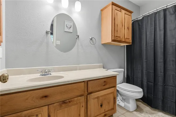 a bathroom with a toilet a sink and mirror