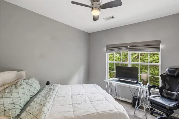 a bedroom with a bed and a large window