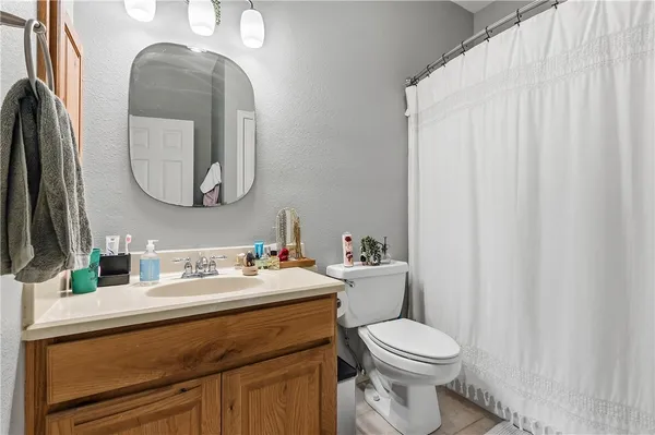 a bathroom with a toilet a sink and mirror