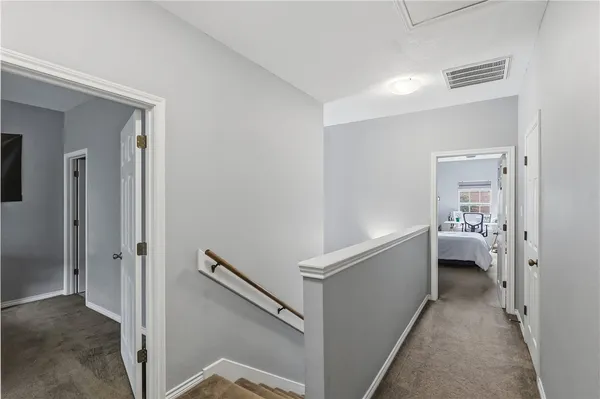 a view of a hallway with bedroom and wooden floor