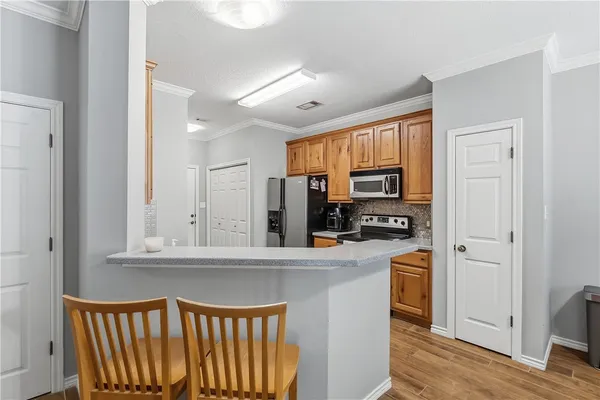 a kitchen with stainless steel appliances granite countertop a refrigerator and a stove top oven