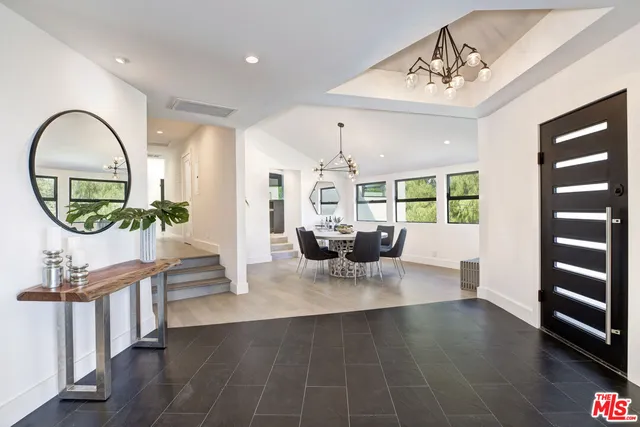 a kitchen with stainless steel appliances kitchen island a large stove a sink dishwasher and white cabinets with wooden floor