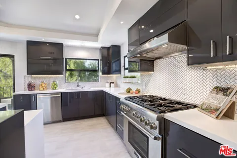 a large kitchen with kitchen island a large window in it