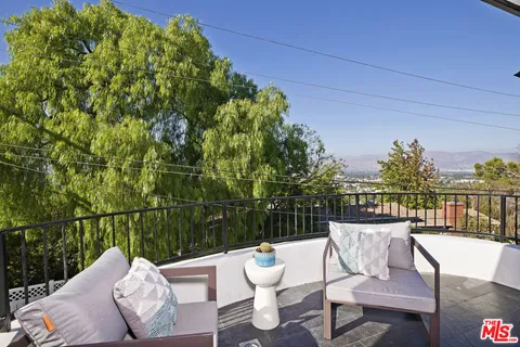 a view of a chairs and table in the roof deck