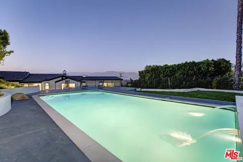 a view of a swimming pool and lounge chairs
