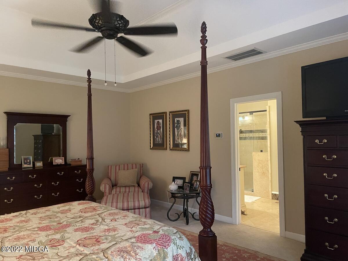 1715 Maynards Mill Road Forsyth, GA 31029 - Photo 23 of 36 a bedroom with a bed and a flat tv screen on dresser