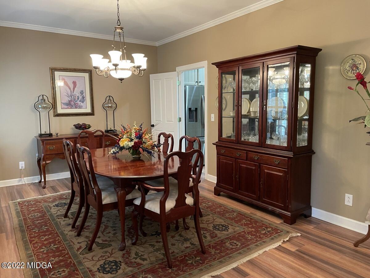 1715 Maynards Mill Road Forsyth, GA 31029 - Photo 6 of 36 a view of a dining room with furniture a chandelier and wooden floor